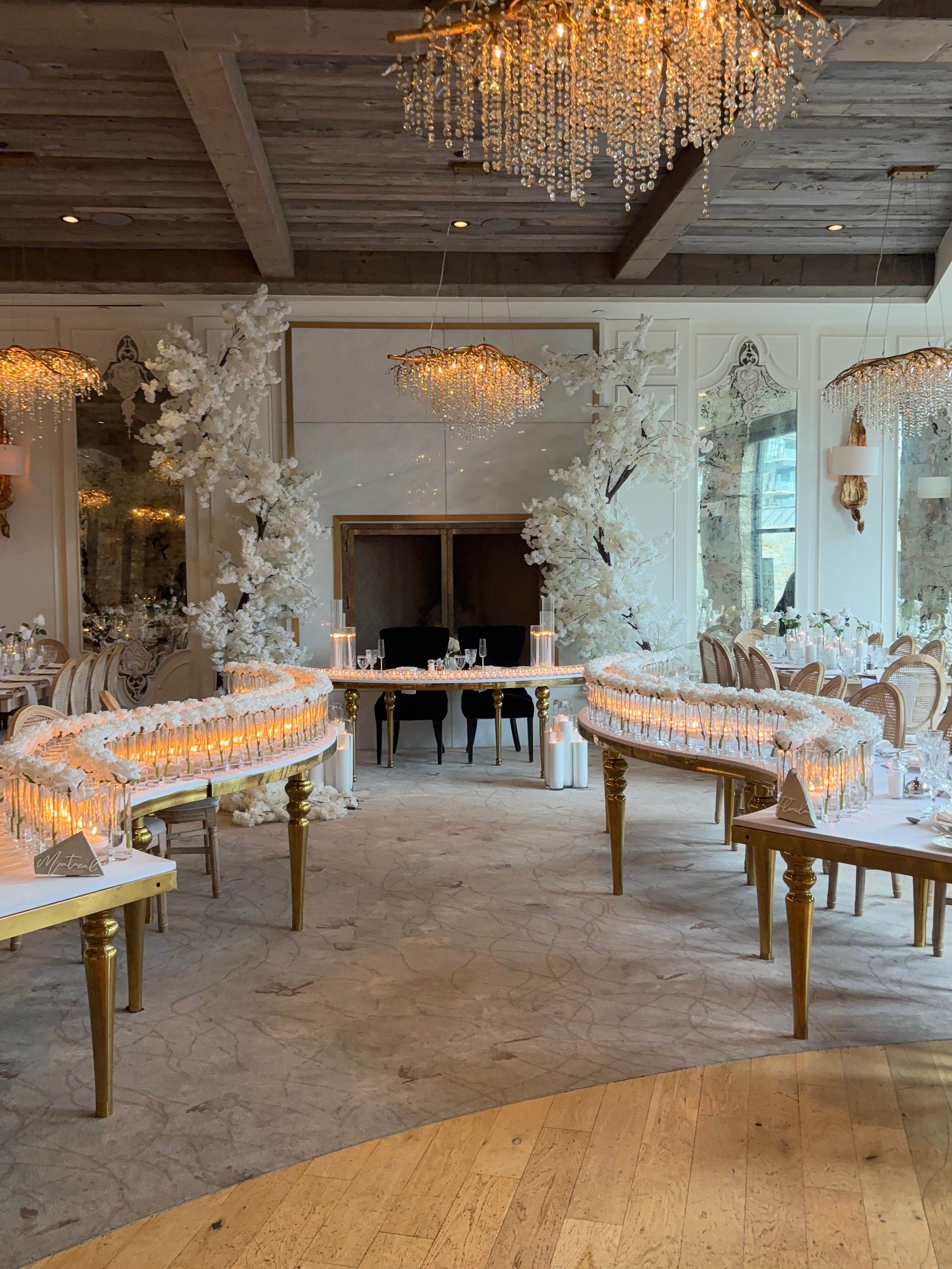 wedding reception with elegant chandeliers and floral arrangements.